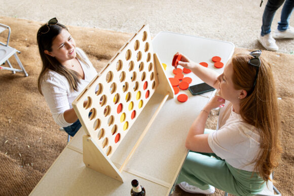 two women play giant connect-four
